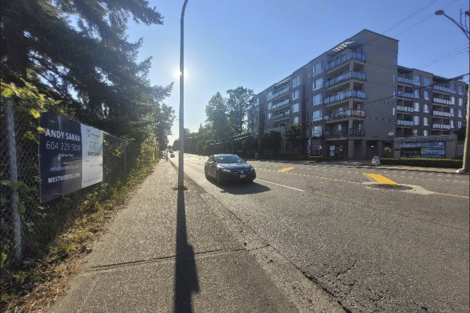 Looking east along 104 Avenue from the property, with a six-storey mixed-use building on the opposite corner.