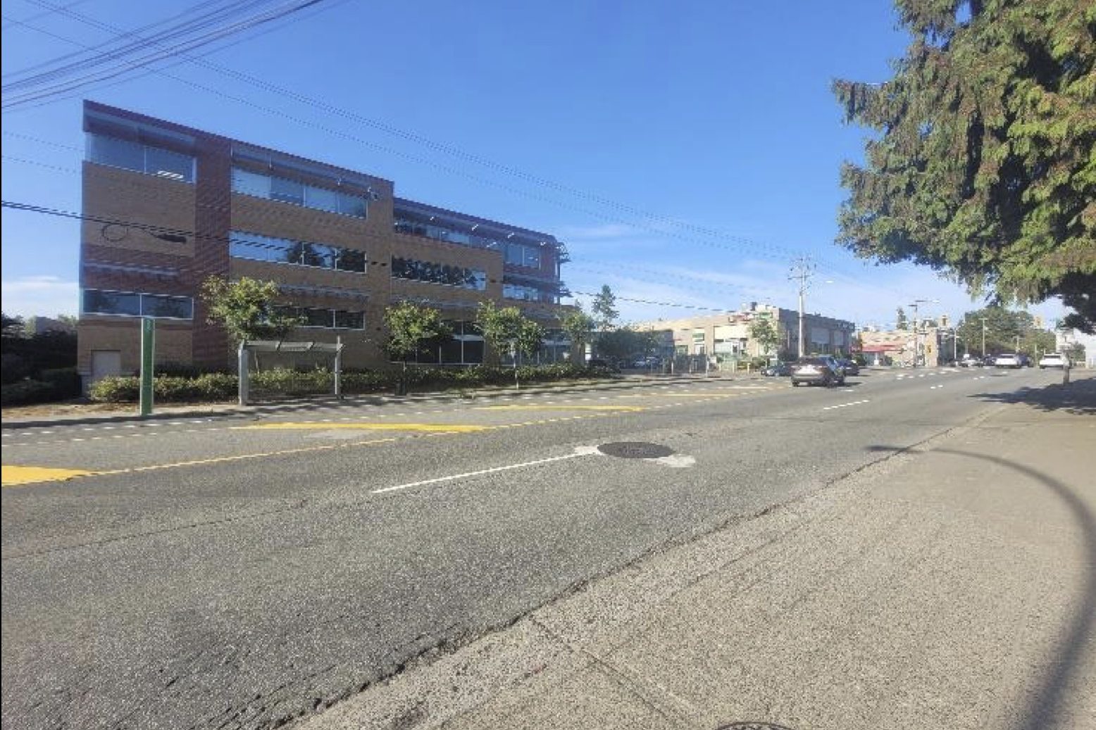 The 104 Avenue streetscape near the property, showing a three-storey commercial office building and retail frontage.